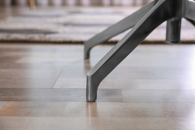 Photo of Modern office chair on wooden floor, closeup