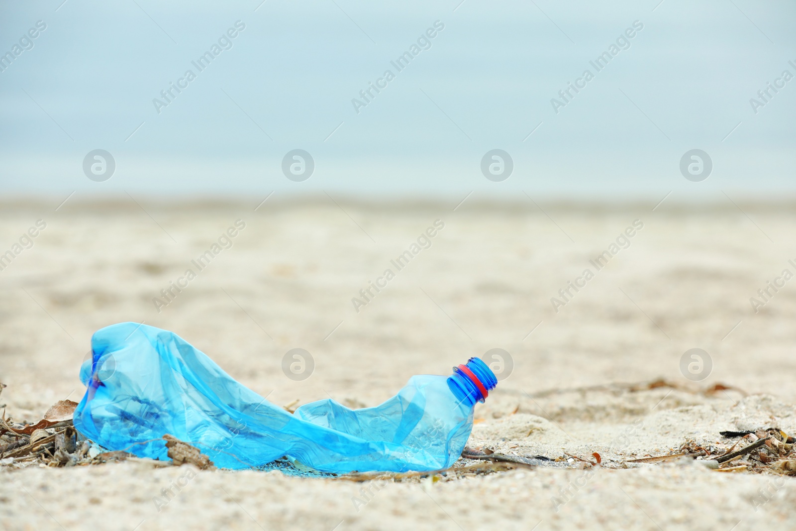 Photo of Used plastic bottle on beach, space for text. Recycling problem