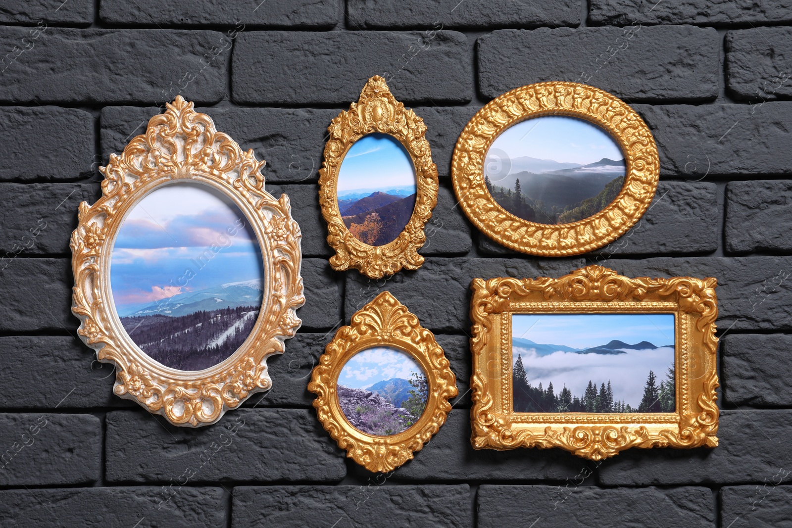 Photo of Vintage frames with photos of beautiful landscapes hanging on dark brick wall