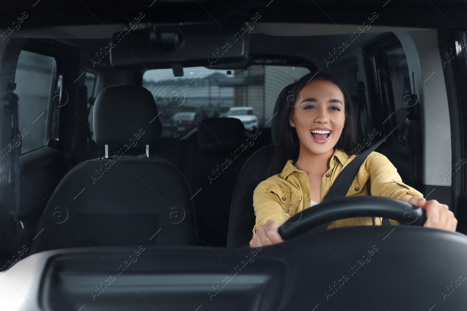 Photo of Listening to radio. Beautiful woman enjoying music in car, view through windshield