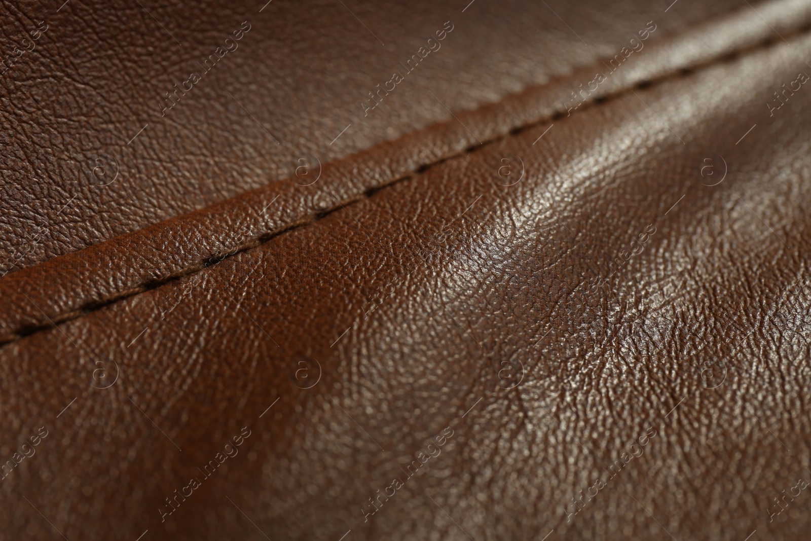 Photo of Brown leather with seam as background, closeup