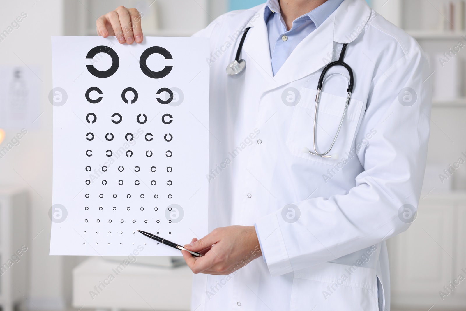 Photo of Ophthalmologist pointing at vision test chart in clinic, closeup