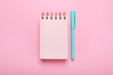Photo of Color marker and notebook on pink background, flat lay