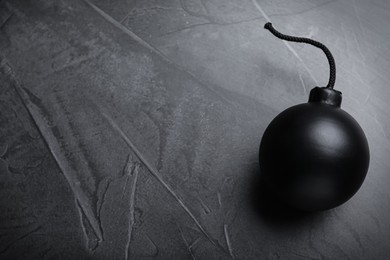 Photo of Sphere shaped bomb with burning fuse on black background, top view. Space for text