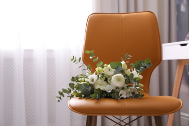 Beautiful bouquet on leather chair indoors. Interior element