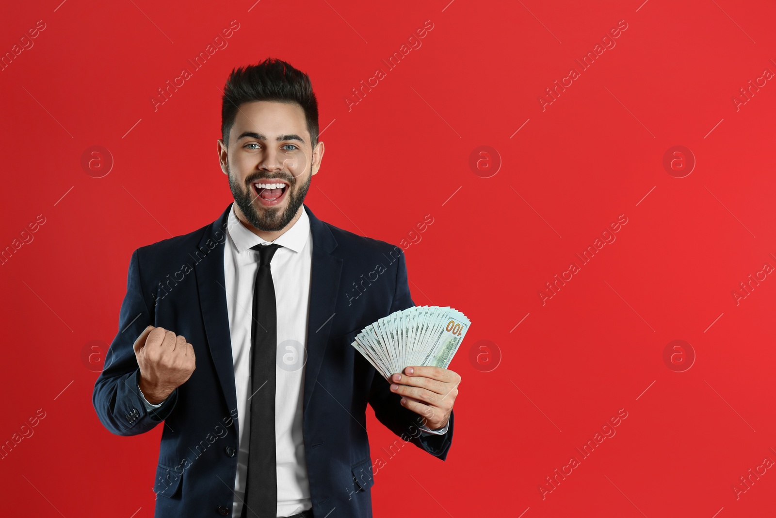 Photo of Emotional young man with money on crimson background. Space for text