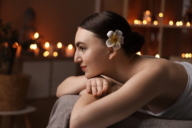 Photo of Spa therapy. Beautiful young woman lying on massage table in salon, space for text