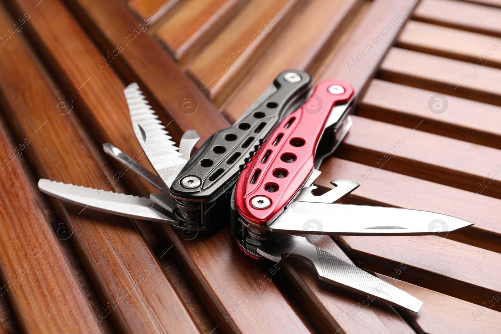 Photo of Modern compact portable multitool on wooden table, closeup