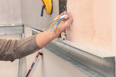 Photo of Worker installing socket in tile indoors, closeup