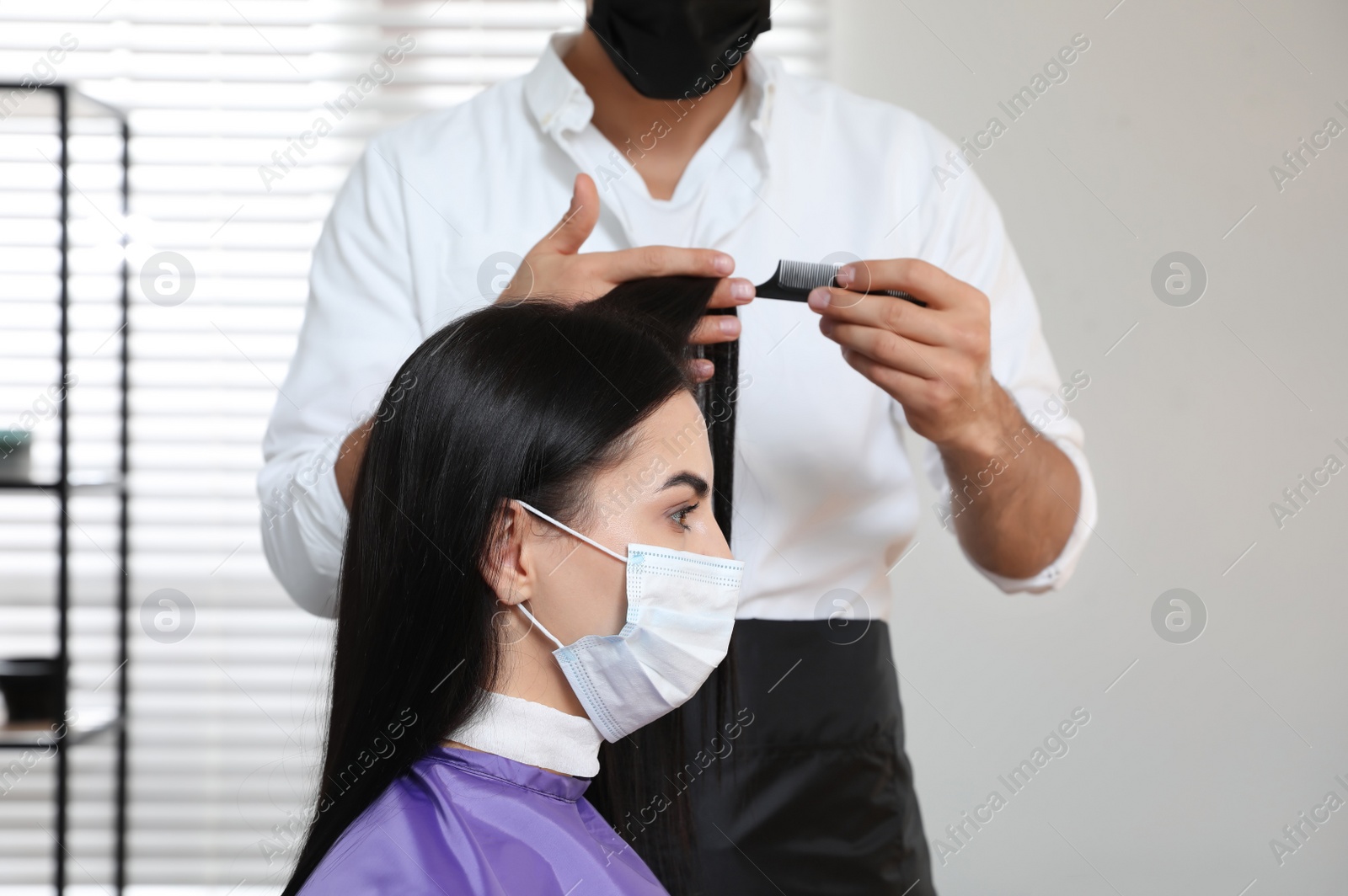 Photo of Professional stylist working with client in salon. Hairdressing services during Coronavirus quarantine