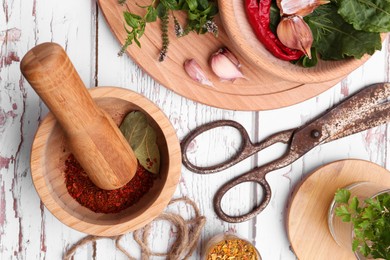 Photo of Mortar with pestle and different ingredients on white wooden table, flat lay