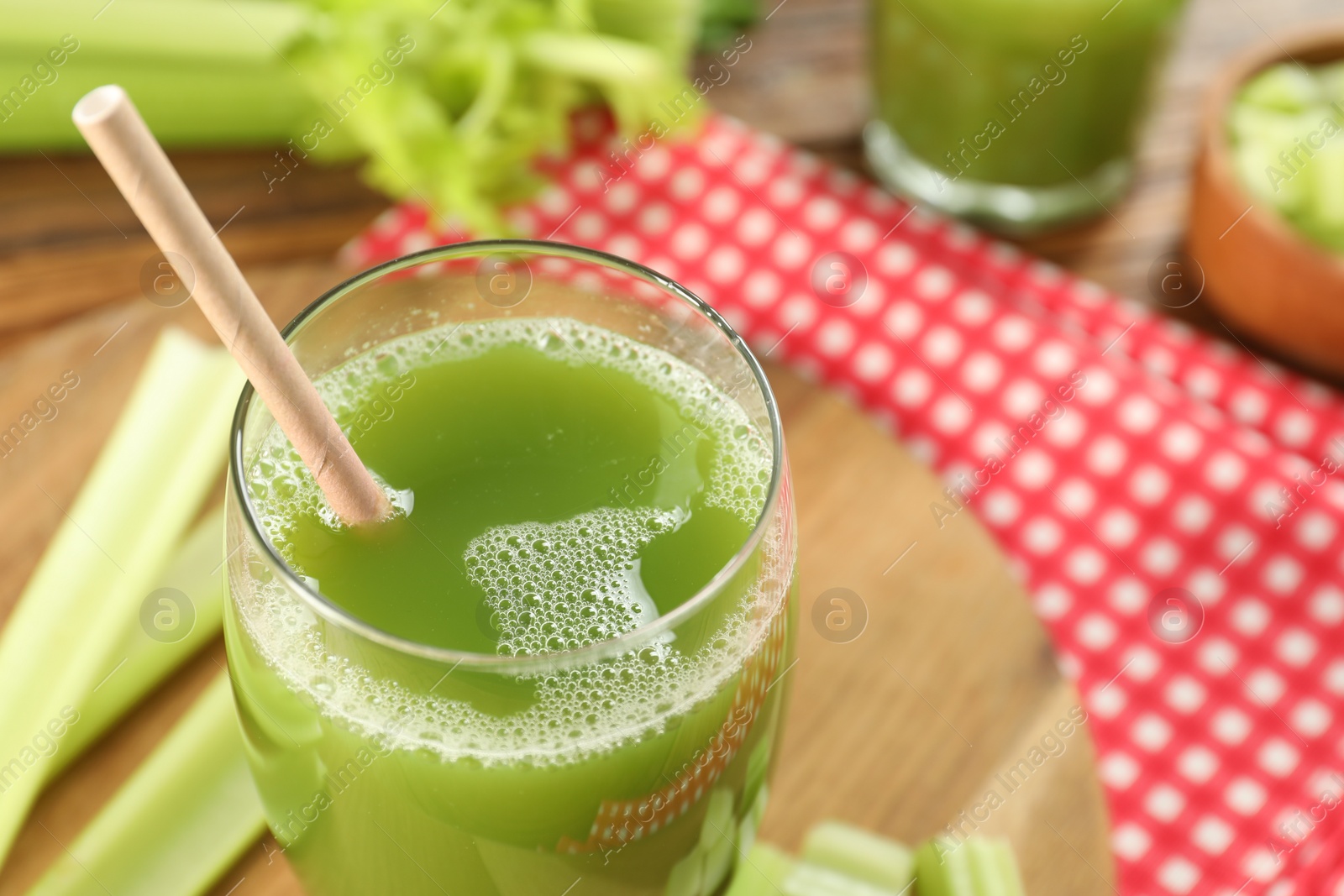 Photo of Glass of delicious celery juice and vegetables on wooden board, closeup