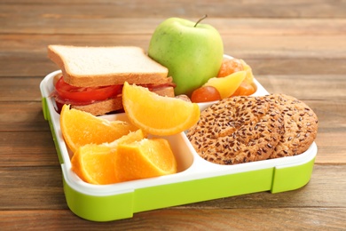 Lunch box with appetizing food on wooden table