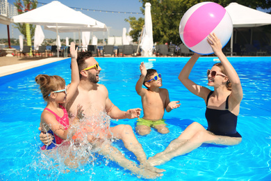 Photo of Happy family having fun in swimming pool