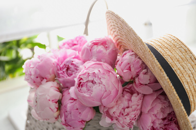 Photo of Bouquet of beautiful pink peonies and hat indoors, closeup