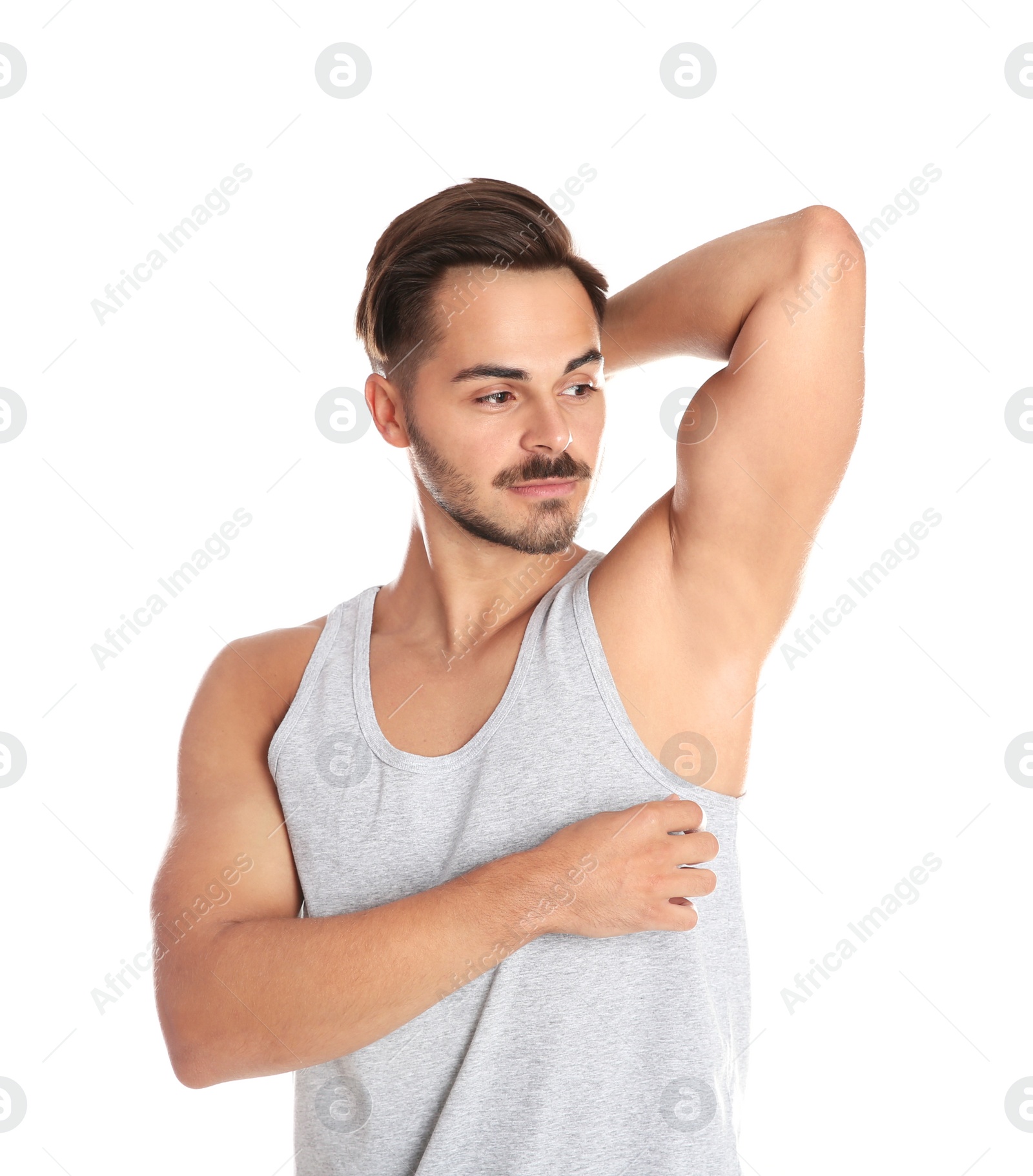 Photo of Handsome young man showing armpit on white background. Using deodorant