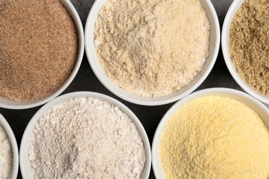 Photo of Bowls with different types of flour on table, top view