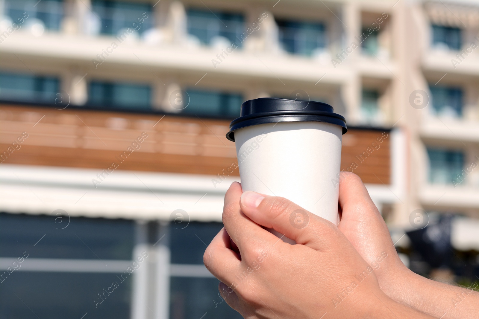 Photo of Woman holding takeaway coffee cup outdoors, closeup. Space for text