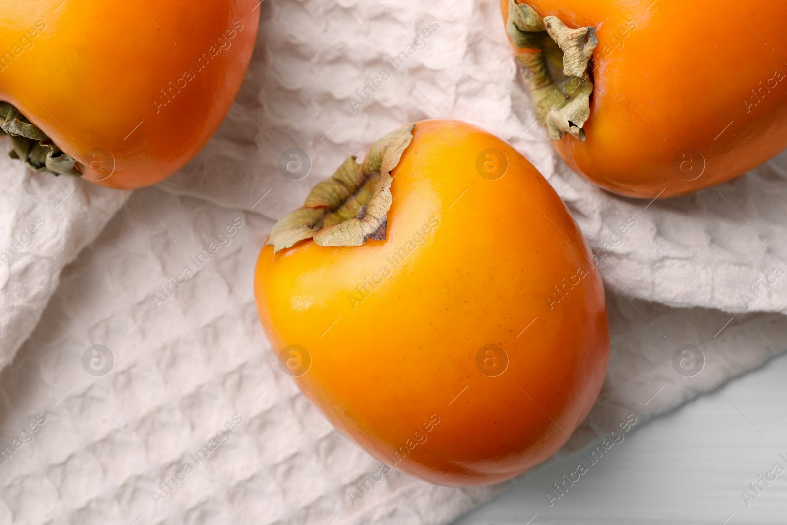 Photo of Delicious ripe persimmons on white table, top view