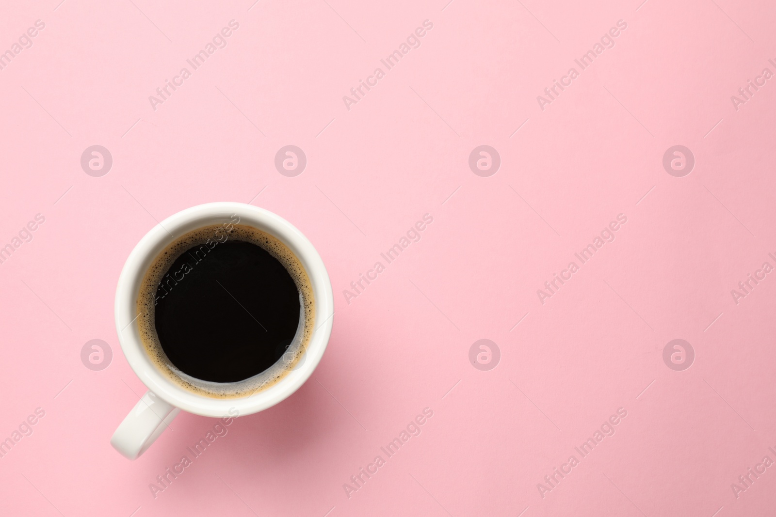 Photo of Fresh coffee in cup on pink background, top view. Space for text