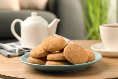 Photo of Delicious sugar cookies and tea on wooden table indoors