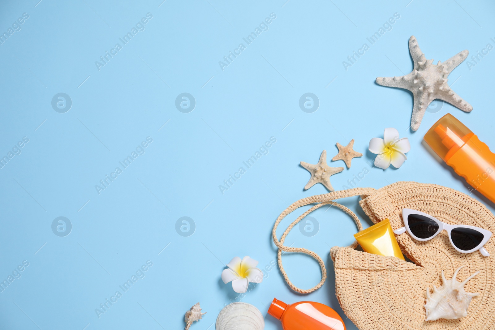 Photo of Flat lay composition with beach items on light blue background. Space for text