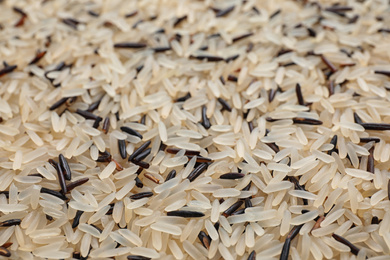 Photo of Mix of different brown and polished rice as background, closeup