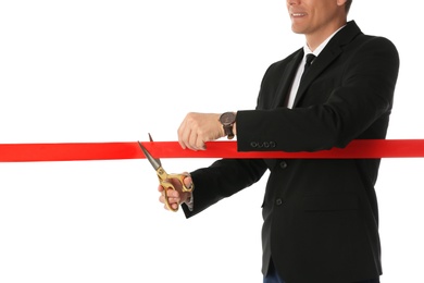 Man in office suit cutting red ribbon isolated on white, closeup