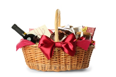 Photo of Wicker basket full of gifts isolated on white