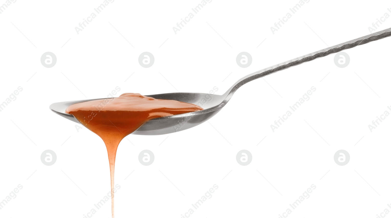 Photo of Tasty caramel sauce pouring from spoon isolated on white