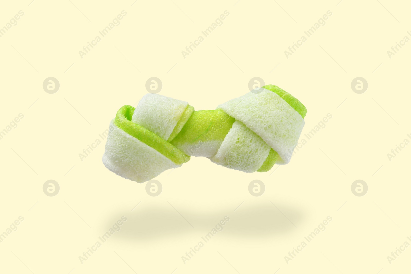 Image of Bone dog treat in air on beige background