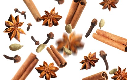 Image of Aromatic anise stars, cinnamon, cloves and cardamom falling on white background
