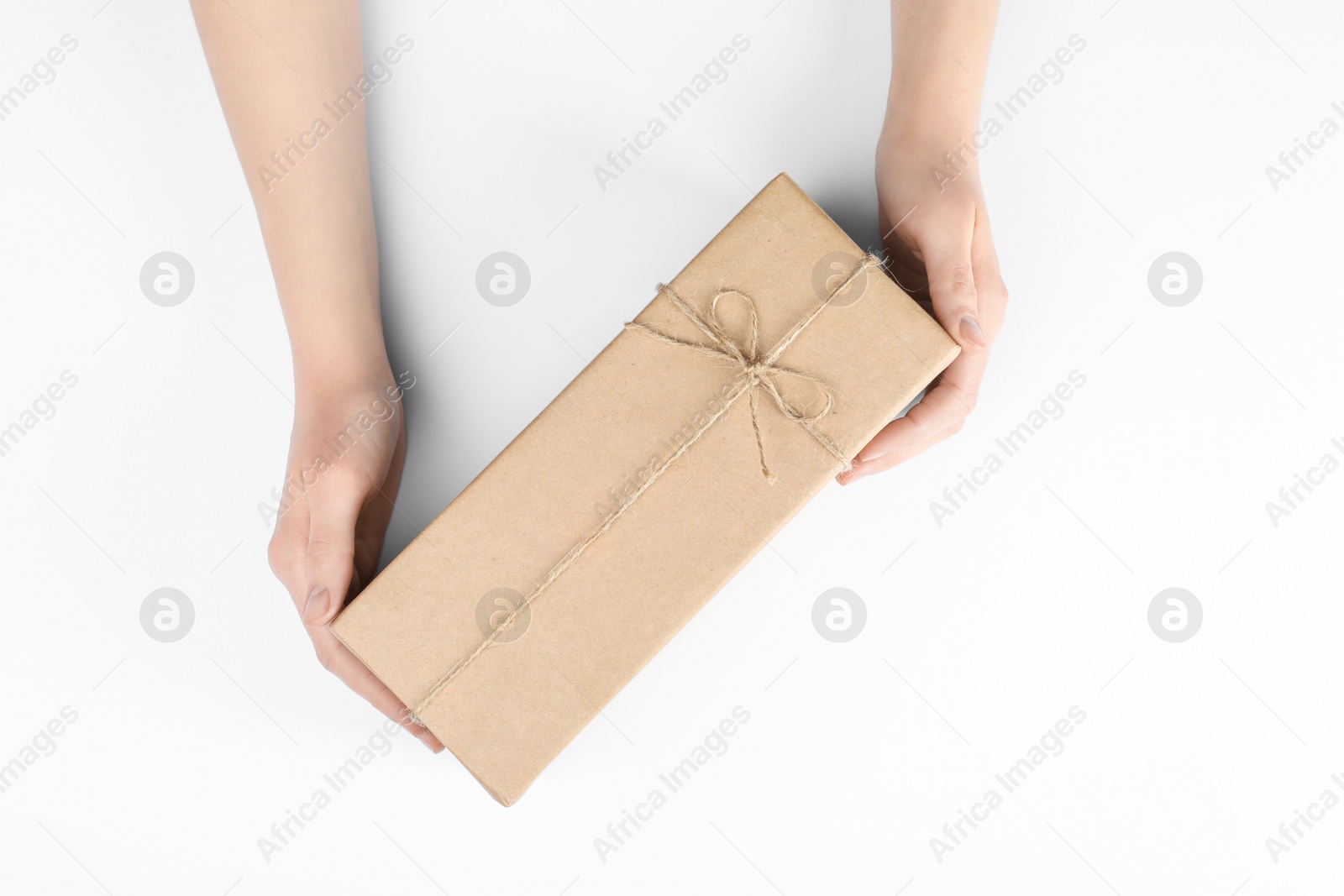 Photo of Woman holding parcel wrapped in kraft paper on white background, top view