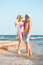 Photo of Young couple spending time together on beach