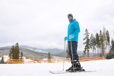 Photo of Male skier on slope at resort, space for text. Winter vacation