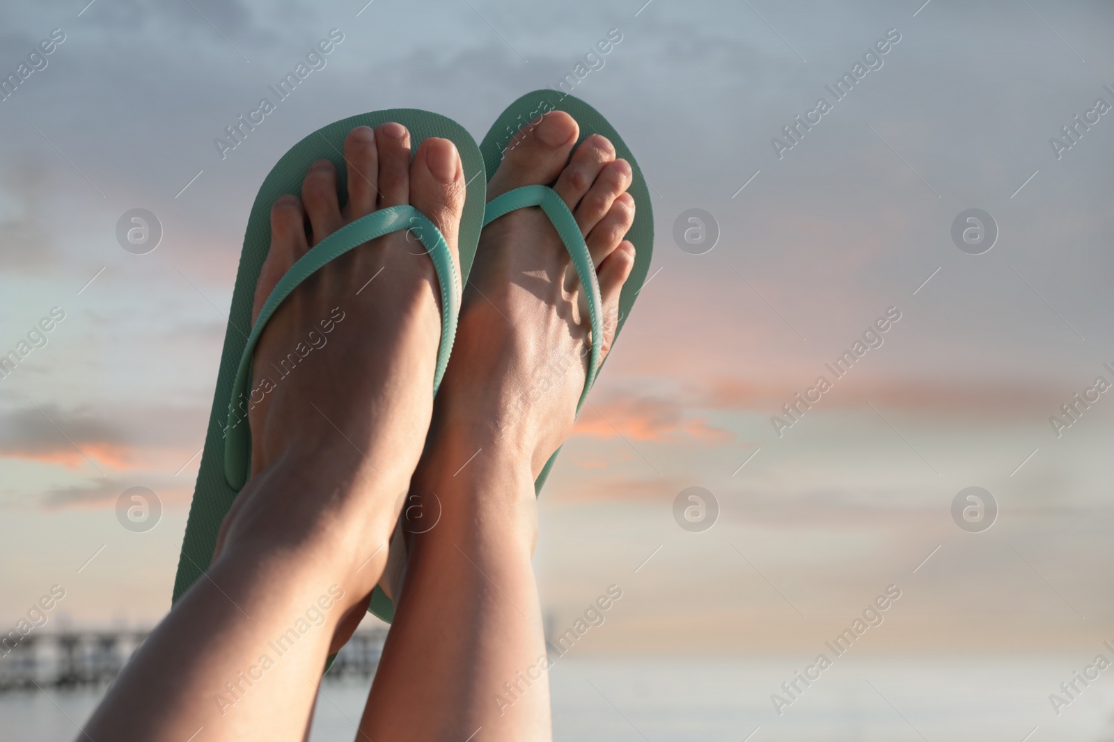 Photo of Woman in stylish flip flops against sky, closeup. Space for text