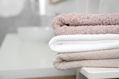 Photo of Fresh laundry on table in bathroom, closeup