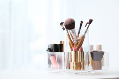 Photo of Organizer with makeup cosmetic products on table indoors. Space for text