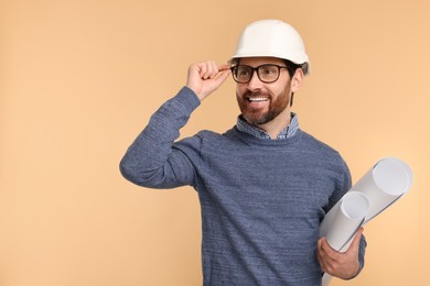 Architect in hard hat with drafts on beige background, space for text