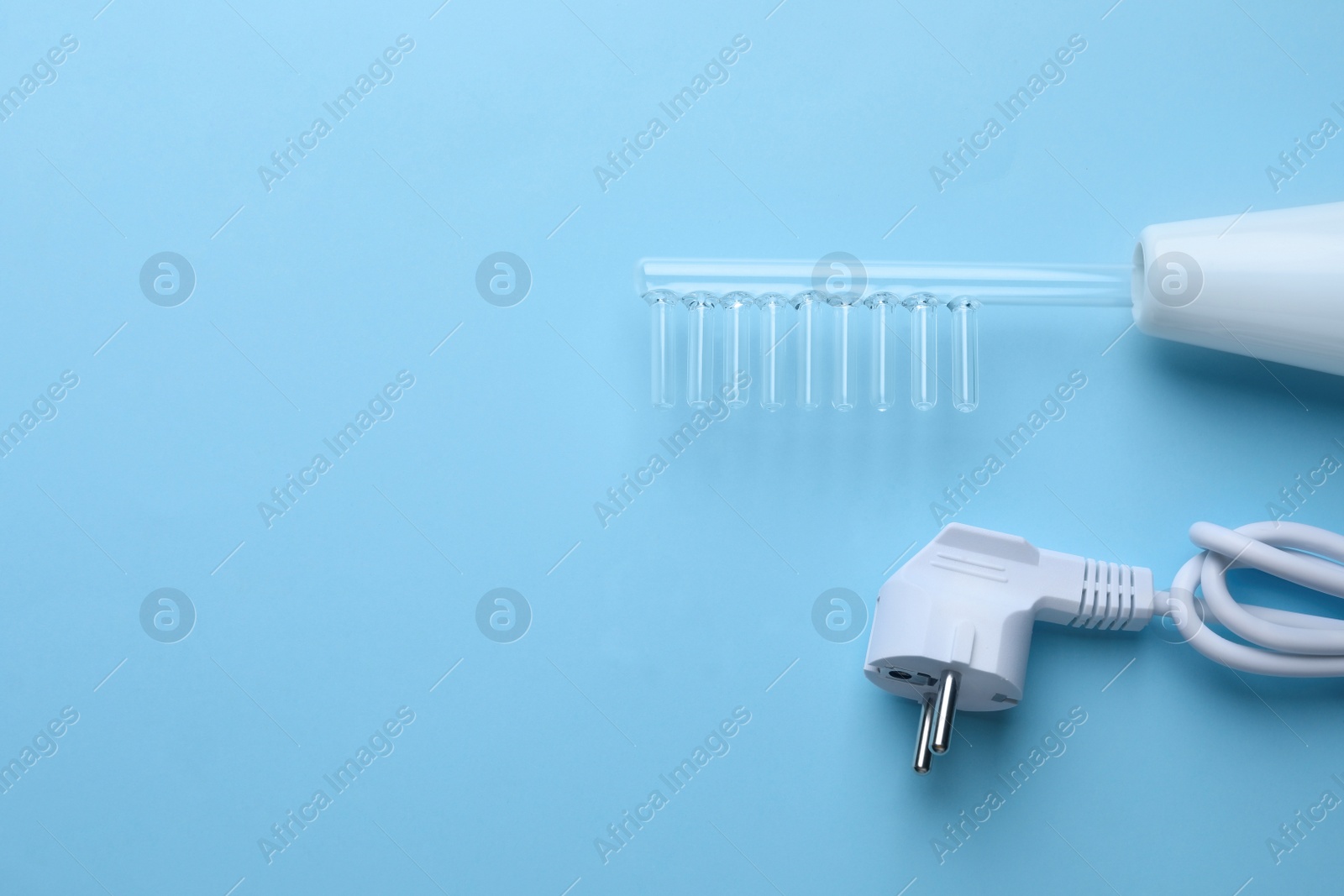 Photo of Modern darsonval on light blue background, flat lay. Space for text