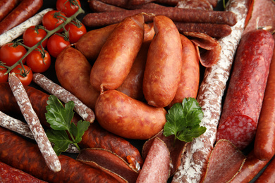 Photo of Different tasty sausages as background, closeup view