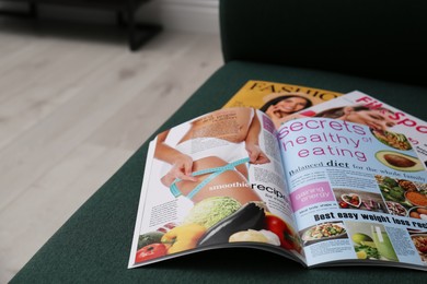 Photo of Different lifestyle magazines on comfortable sofa indoors