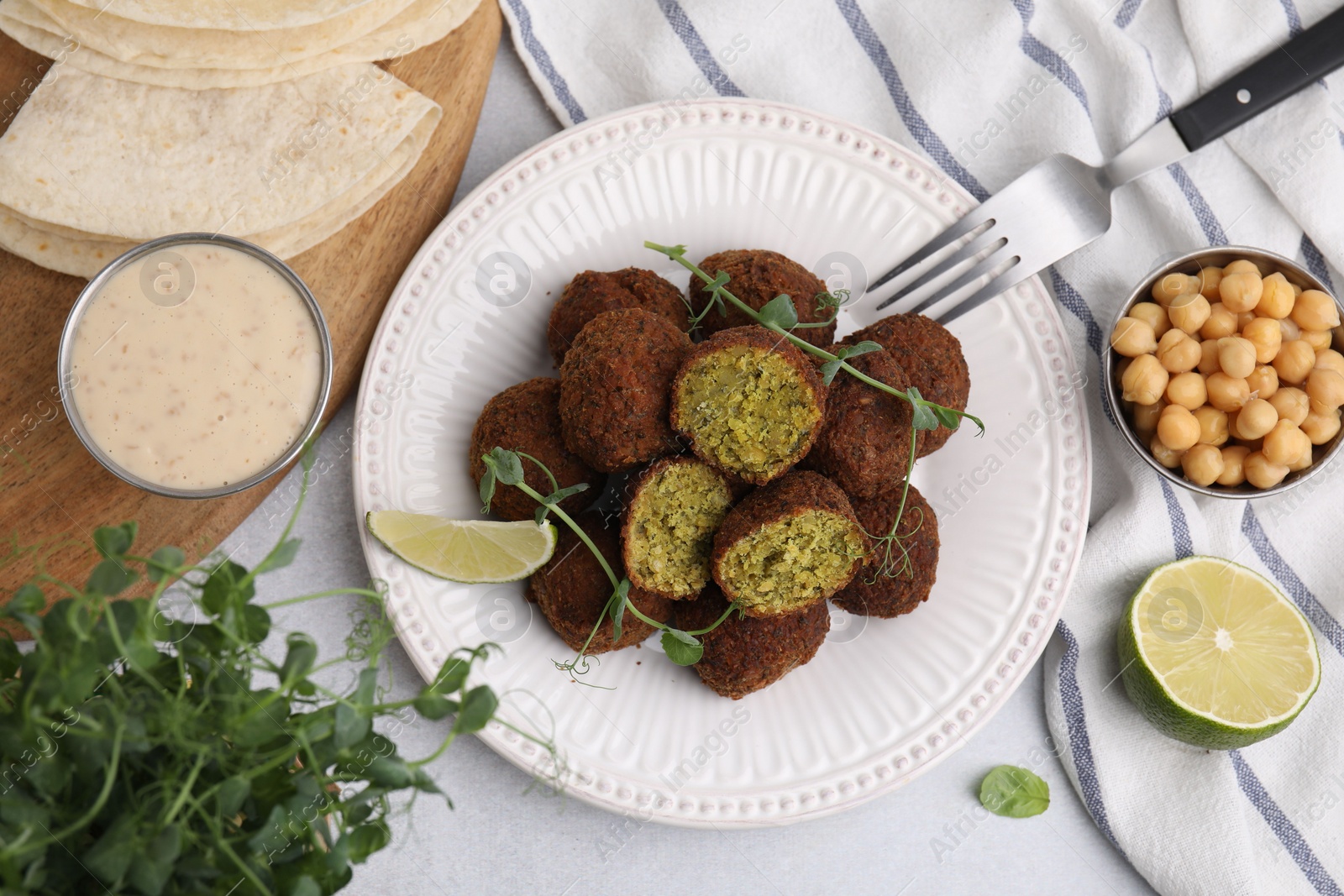 Photo of Delicious falafel balls served on light table, flat lay