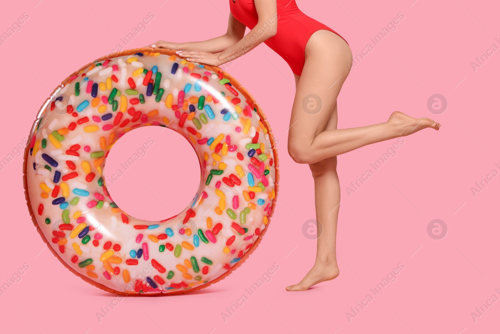 Photo of Young woman with inflatable ring against pink background, closeup