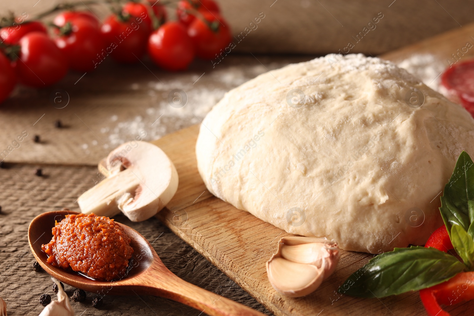 Photo of Pizza dough and products on wooden table, closeup