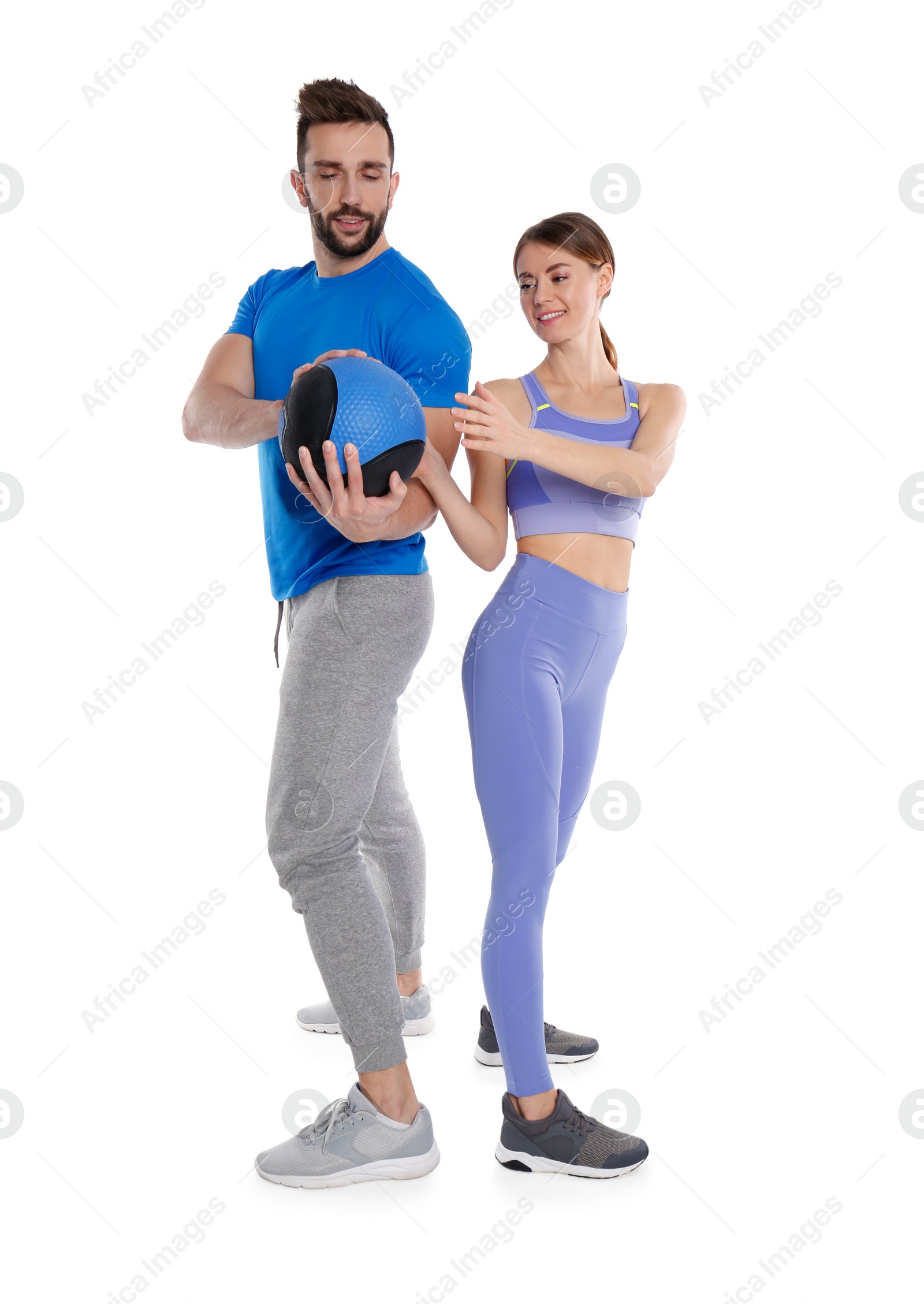 Photo of Athletic couple doing exercise with medicine ball on white background