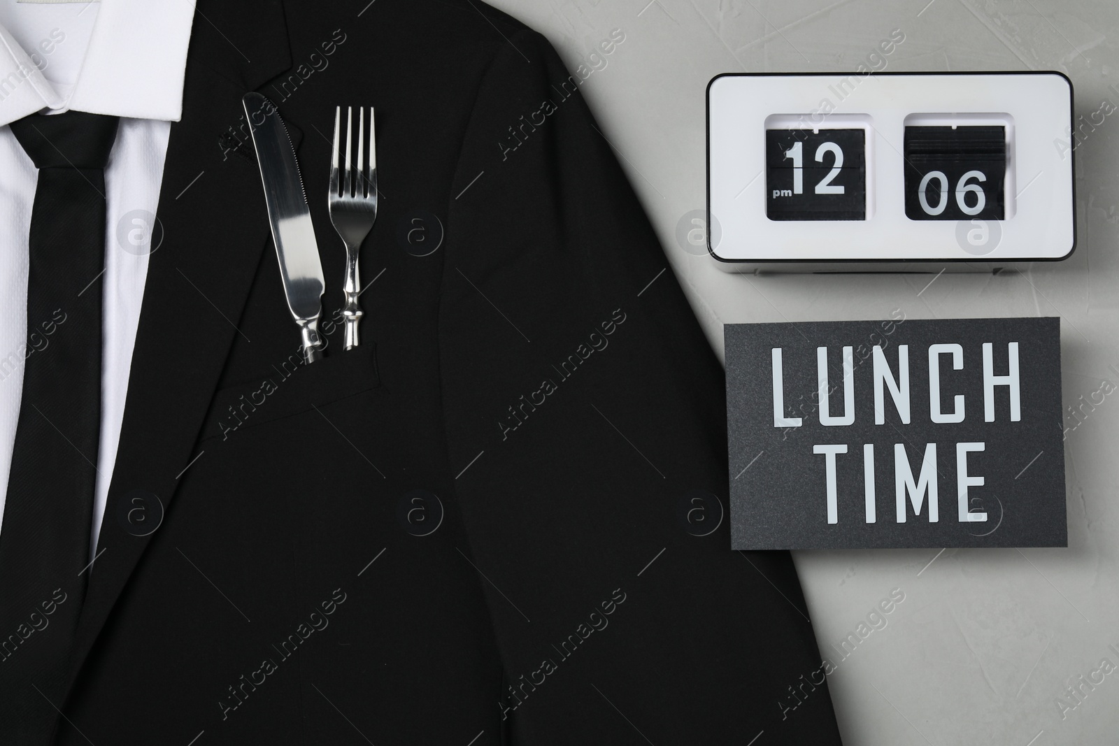 Image of Creative business lunch layout. Men's jacket with cutlery in pocket, card and flip clock on light gray background, flat lay