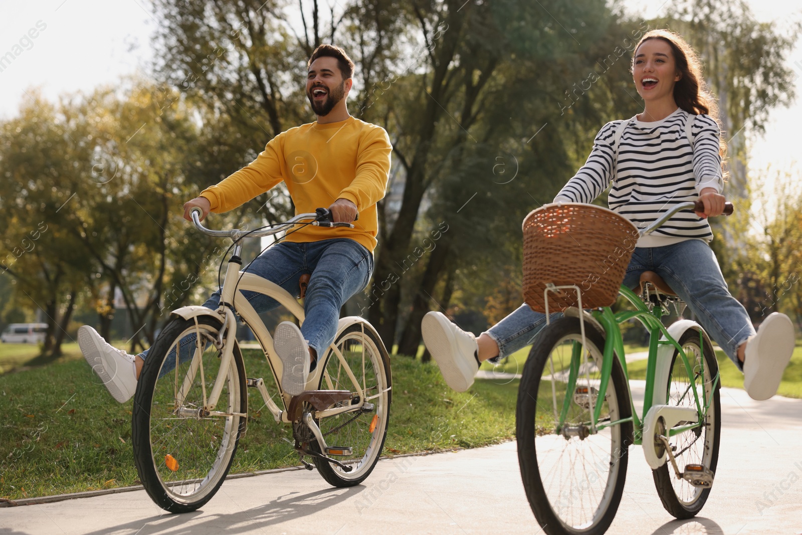 Photo of Beautiful young couple riding bicycles in park