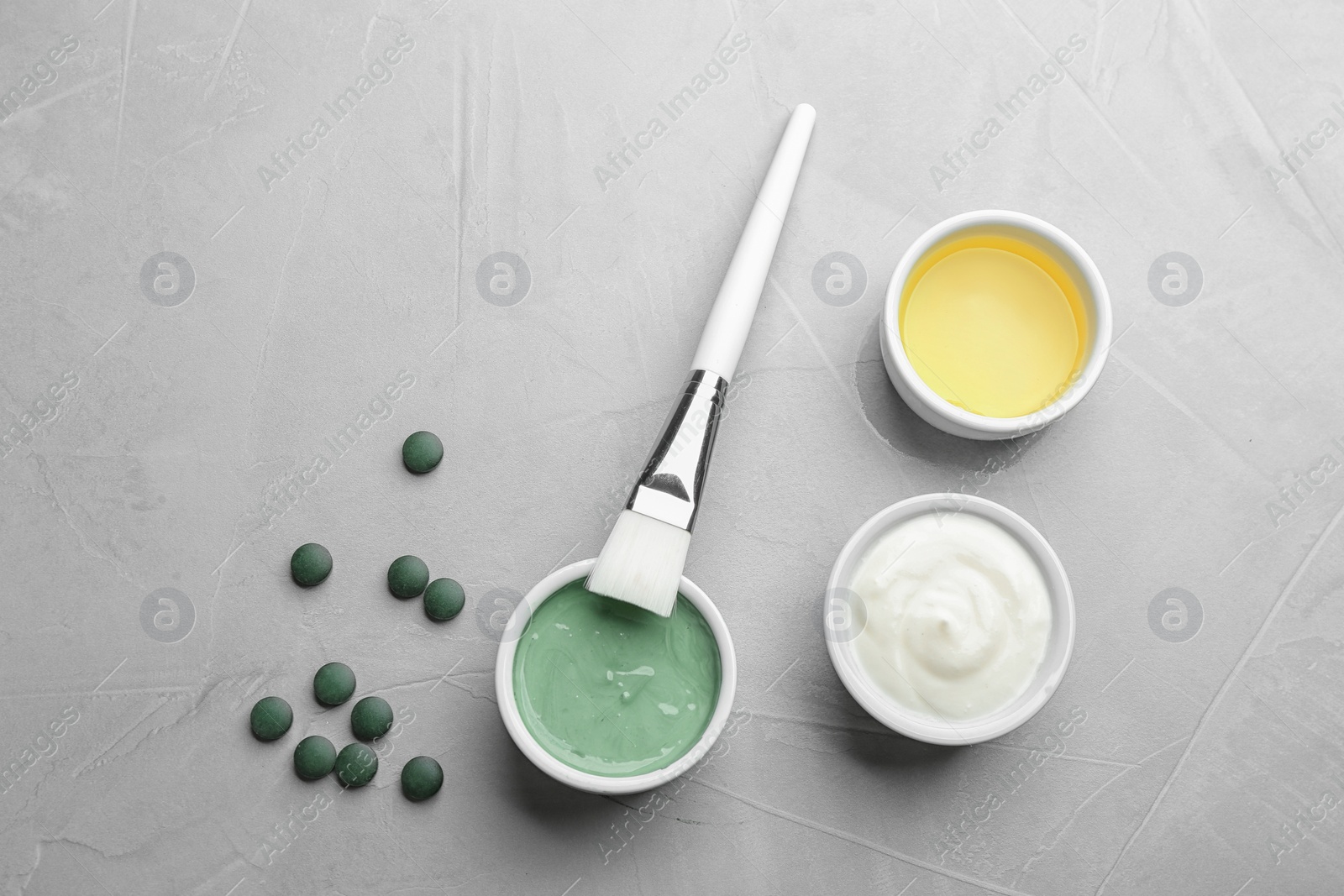 Photo of Flat lay composition with freshly made spirulina facial mask on light grey table