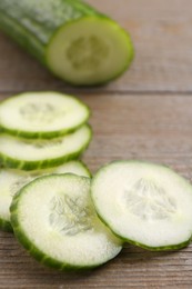 Cut ripe cucumber on wooden table, closeup